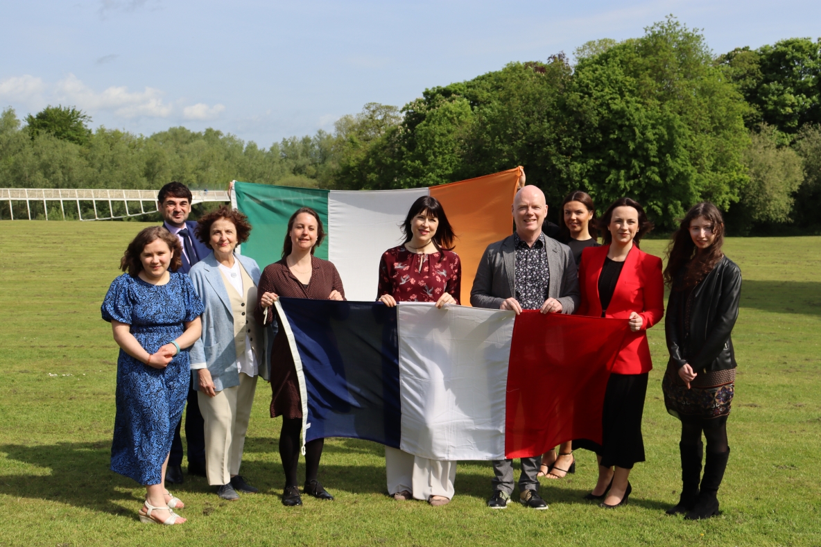 Group photo with people holding Irish and French flags