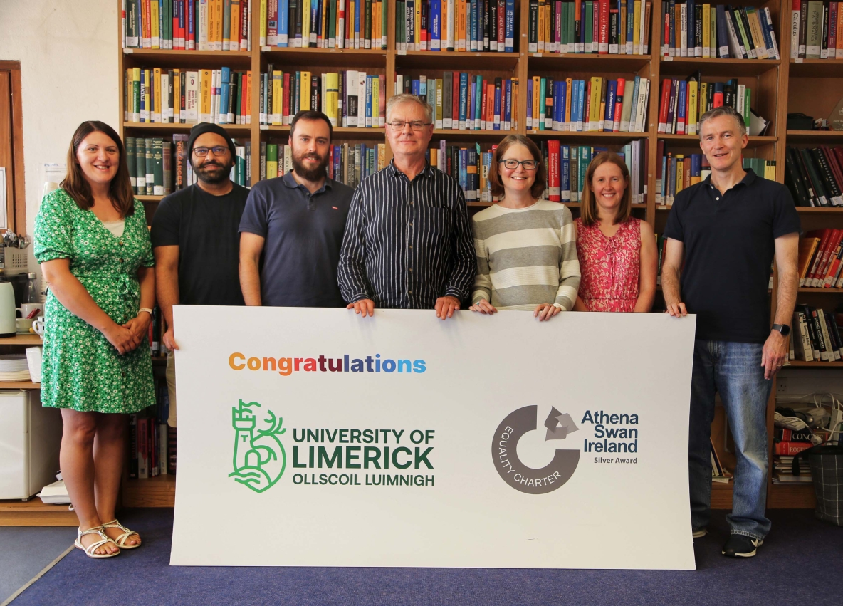 Members of the Department of Mathematics and Statistics at UL pictured with large sign marking their Athena Swan award