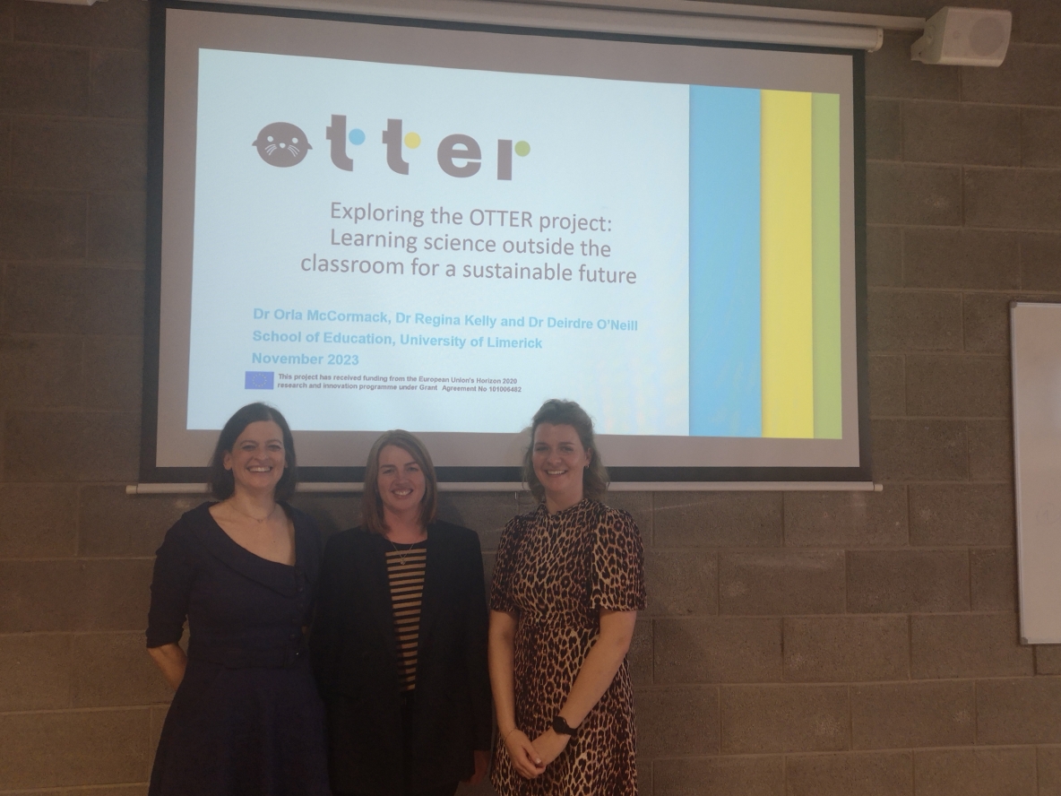 Dr. Orla McCormack, Dr. Elaine Kinsella and Dr. Deirdre O Neill standing in front of a presentation of the OTTER Project