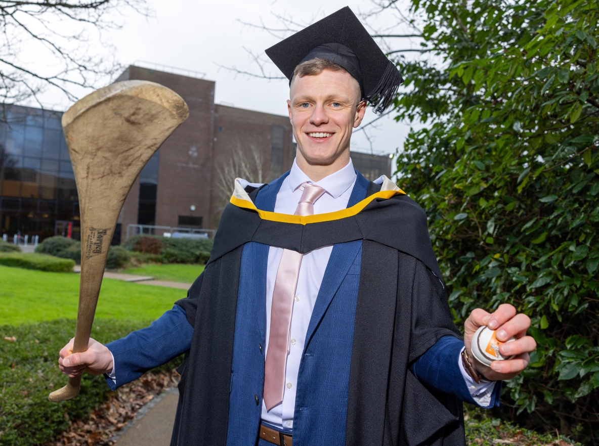 Tipperary hurler Bryan O’Mara who graduated from UL’s Kemmy Business School, pictured in his robes and holding a hurley and sliotar