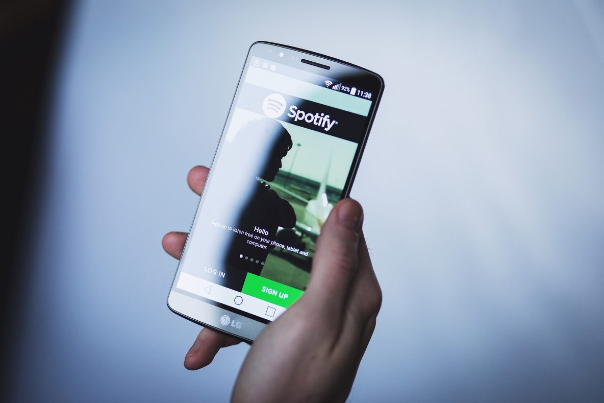 Hand holding phone displaying spotify.